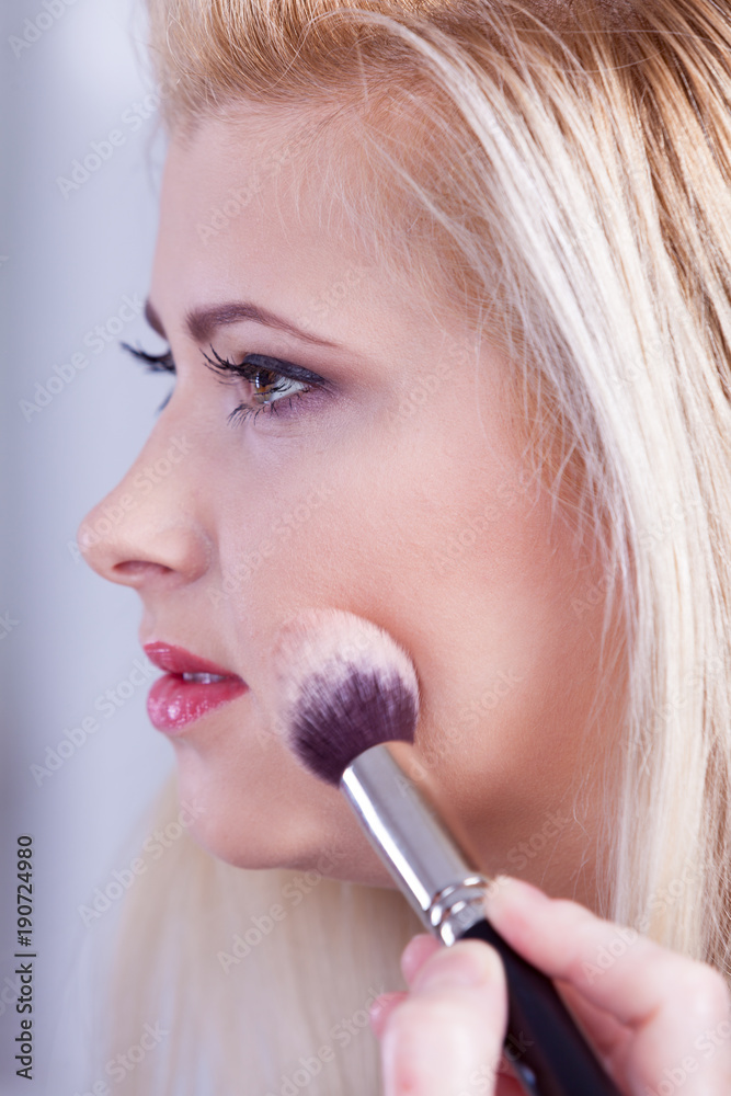 Woman getting her make up done with brush