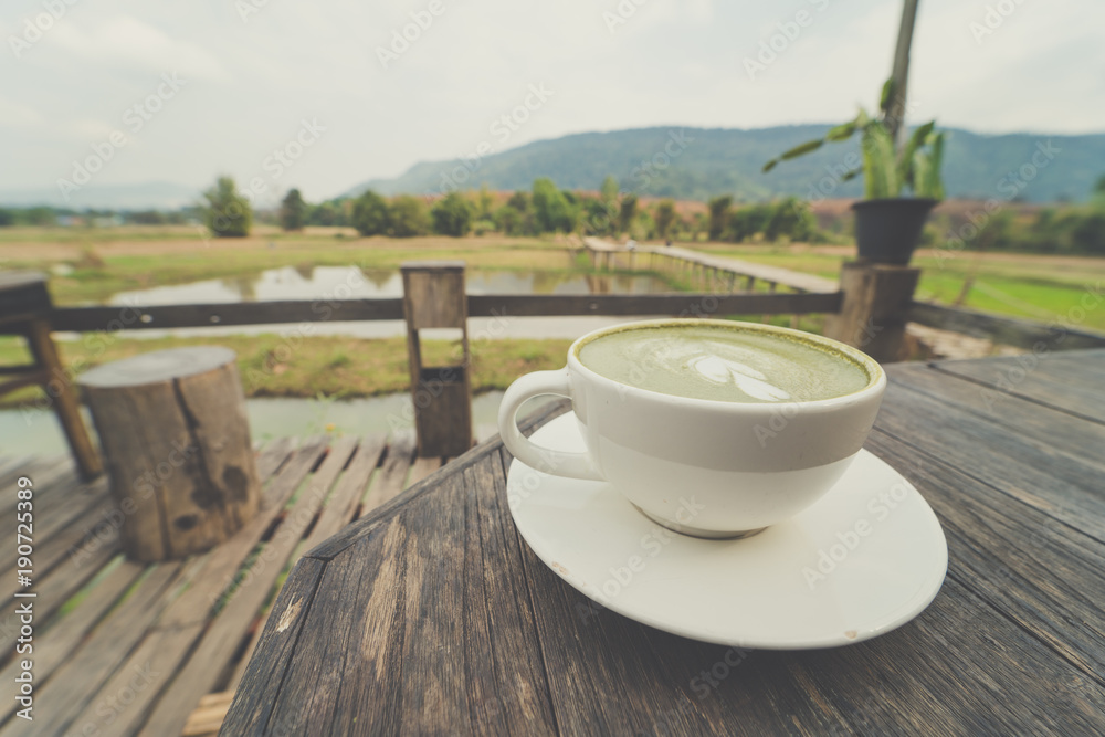 Cup of coffee on wooden table with  beautiful natural background