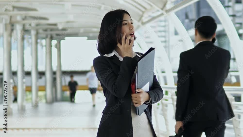 Asian pretty woman and businessman going in opposite direction Asian pretty woman and businessman going in opposite direction