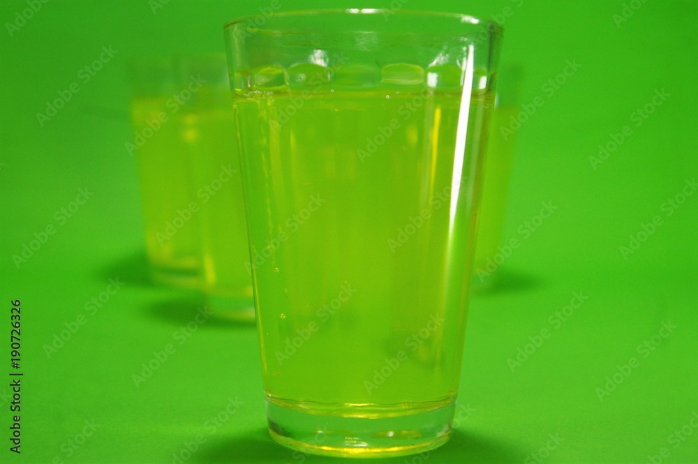 Vasos de licor de absenta transparentes en un fondeo de color verde Vasos de licor de absenta transparentes en un fondeo de color verde