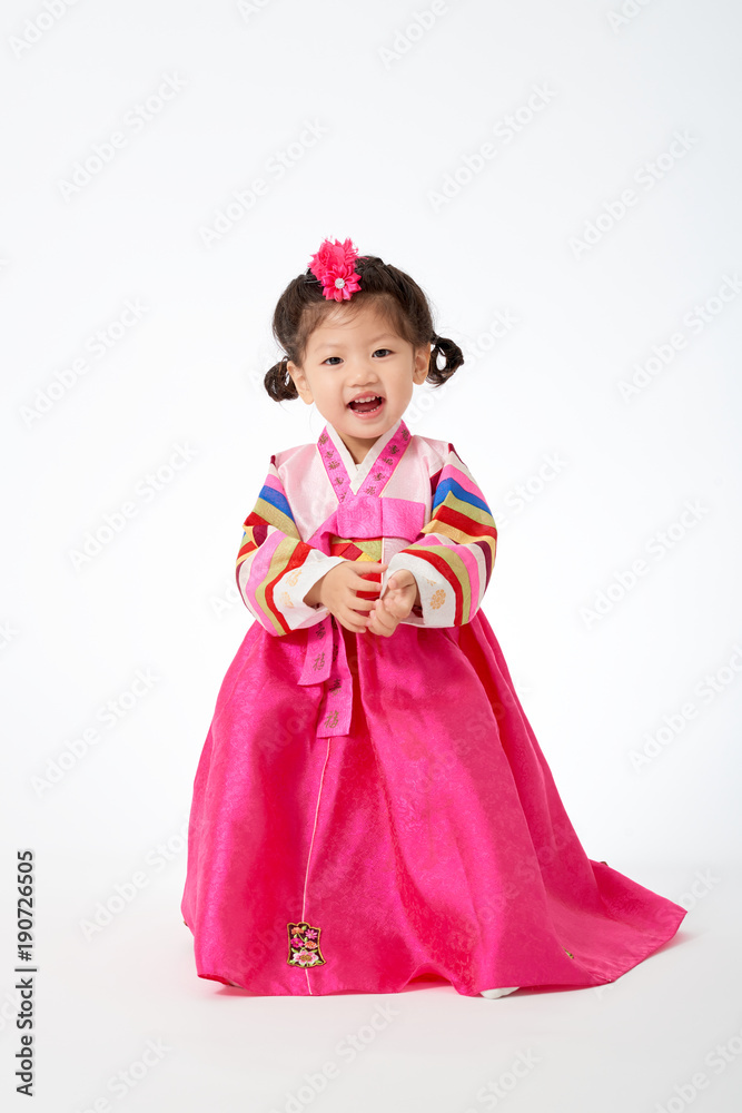 Smile Korean little girl wearing a Traditional Hanbok dress in white  background. The characters on the dress means happiness and healthy. Stock  Photo | Adobe Stock