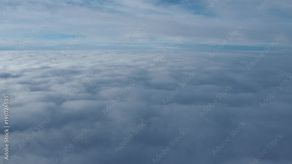 Landscape from the airplane window to a massive sea of clouds in a blue sky Landscape from the airplane window to a massive sea of clouds in a blue sky