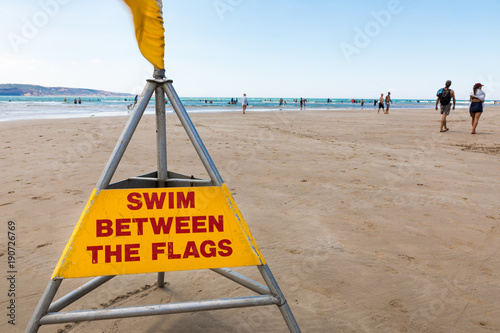 Swim between the flags surf lifesaving sign photo