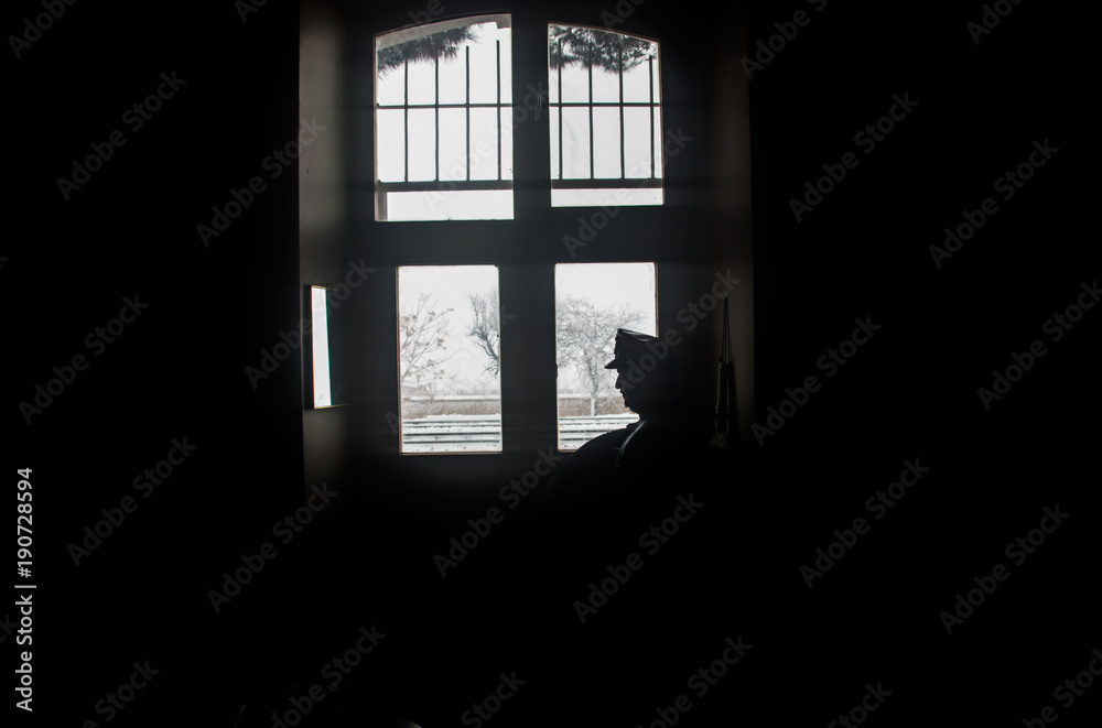 silhouette image of station attendant looking at window