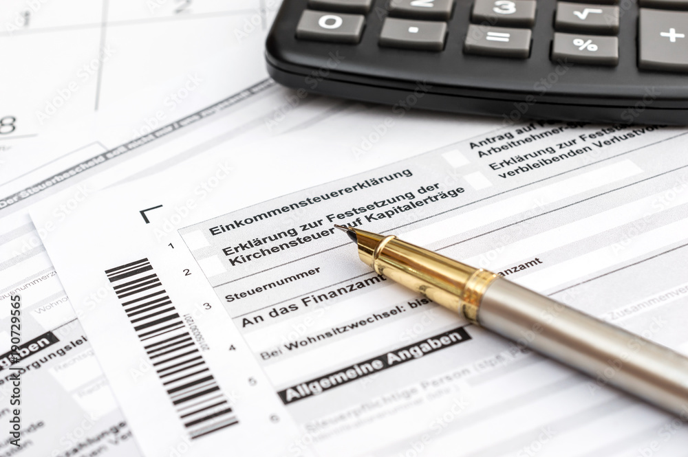 Pen and calculator on the German tax form. Pen and calculator on the German tax form.