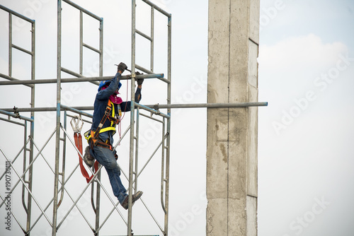 Obraz na plátně Construction worker working on scaffolding in construction site