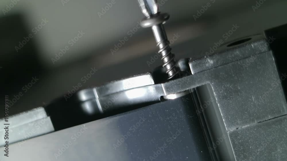 Screwdriver twists (unscrews) the black screw into the body of the device. Macro video