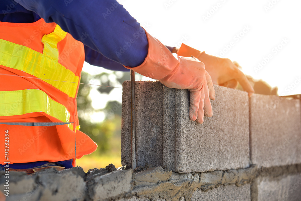 masonry construction worker in standard safety uniform install concrete