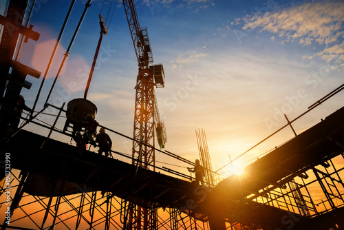 silhouette construction worker Concrete pouring during commercial concreting floors of building in construction site and Civil Engineer or Construction engineer inspec work photo