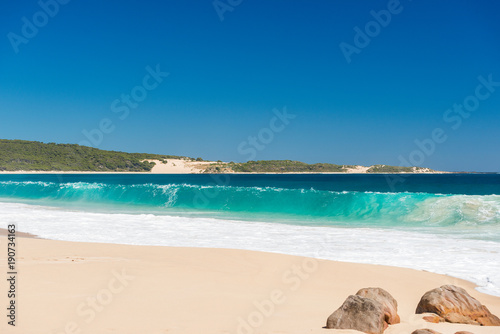 Desserted sandy beach with clear blue waters in summer photo