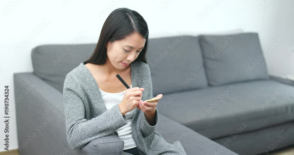 Woman writing yellow sticky note