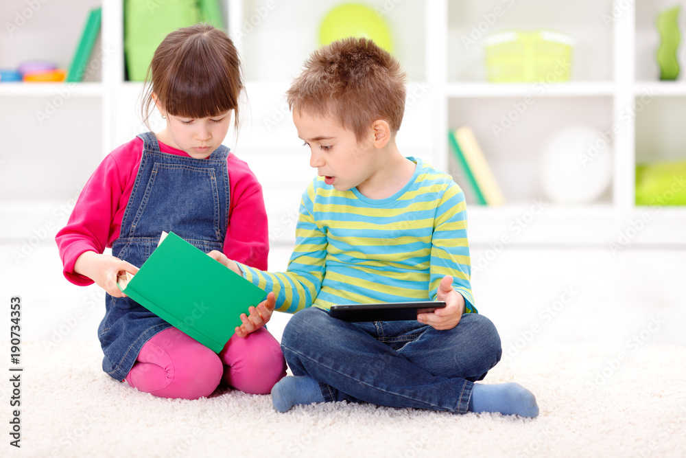 Little sister and brother reading from an interesting book Little sister and brother reading from an interesting book