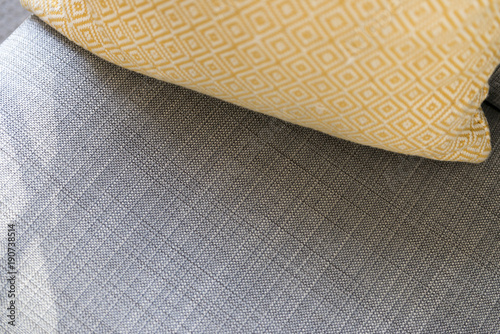 Close Up of Yellow Pillow on Gray Cushion