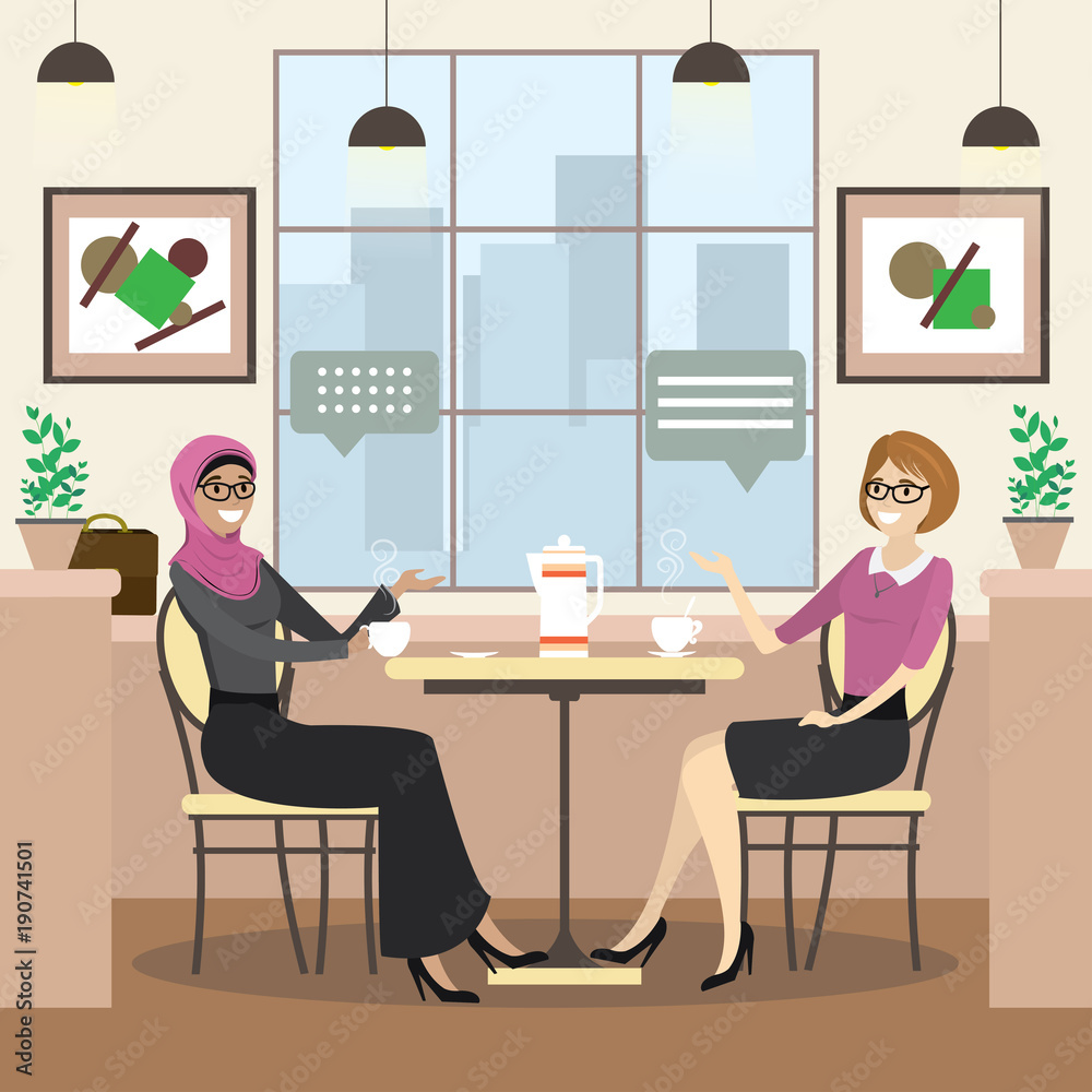 fashion caucasian and arab female is sitting at a table in cozy restaurant fashion caucasian and arab female is sitting at a table in cozy restaurant