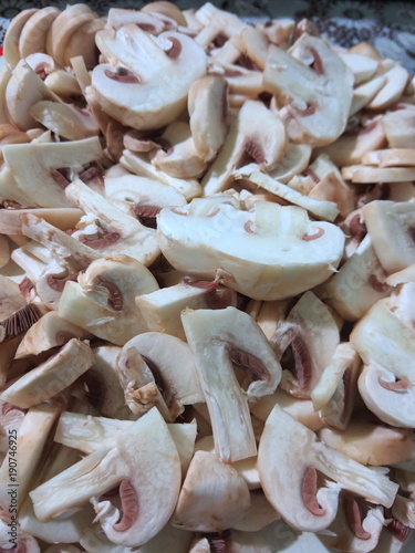 Sliced mushrooms on the board, champignons before cooking, mushrooms in the home kitchen, retro style, American cuisine, vegetarian food