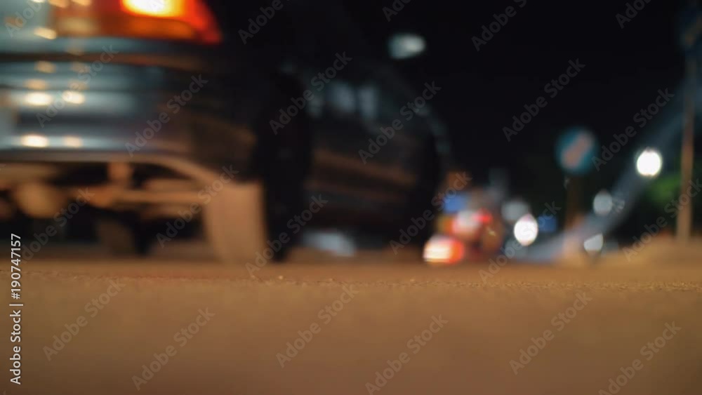 Slow motion shot of cars driving along the street at night. Blur with red backlights. Focus on the road Slow motion shot of cars driving along the street at night. Blur with red backlights. Focus on the road