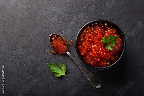 delicious red caviar in black bowl photo