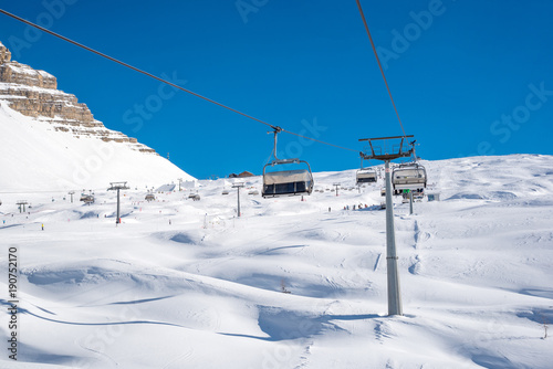 Sunny day in the Alps - ski tracks, ski lifts and snowy mountains