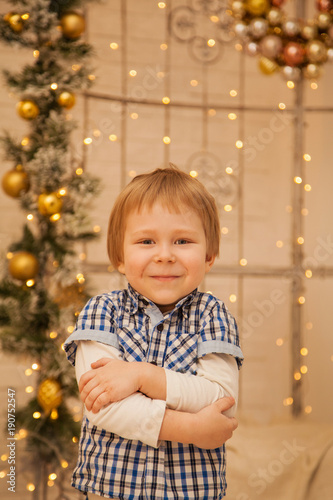 A little boy in the background of beautiful lights. Stylish guy