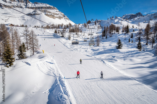Skiers on a ski track on a beautiful sunny day in the Alps photo