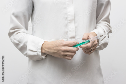 woman in white shirt with syringe in her hands
