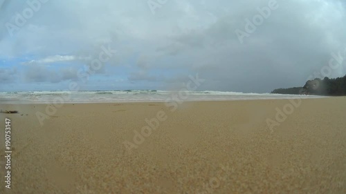 Girl running towards to camera on beach, young woman runner on a sand beach, stormy sea and sky
