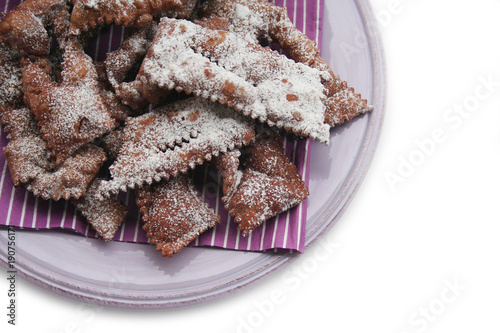 Italian carnival pastry on a plate on white. Traditional carnival chocolate crostoli 