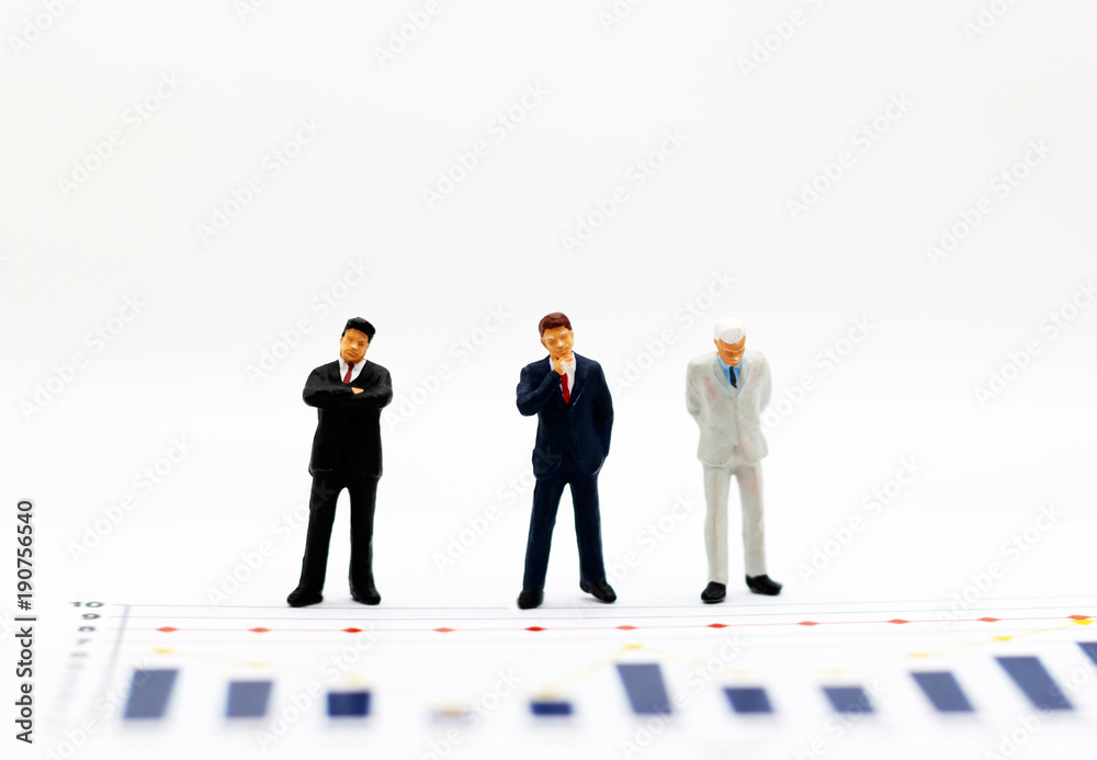 Miniatrue people: Businessman looking at the graph. Concept of business. Miniatrue people: Businessman looking at the graph. Concept of business.