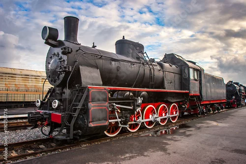 Obraz Lokomotywa parowa z czerwonymi kołami. Lokomotywa retro na szynach. Czarna lokomotywa.