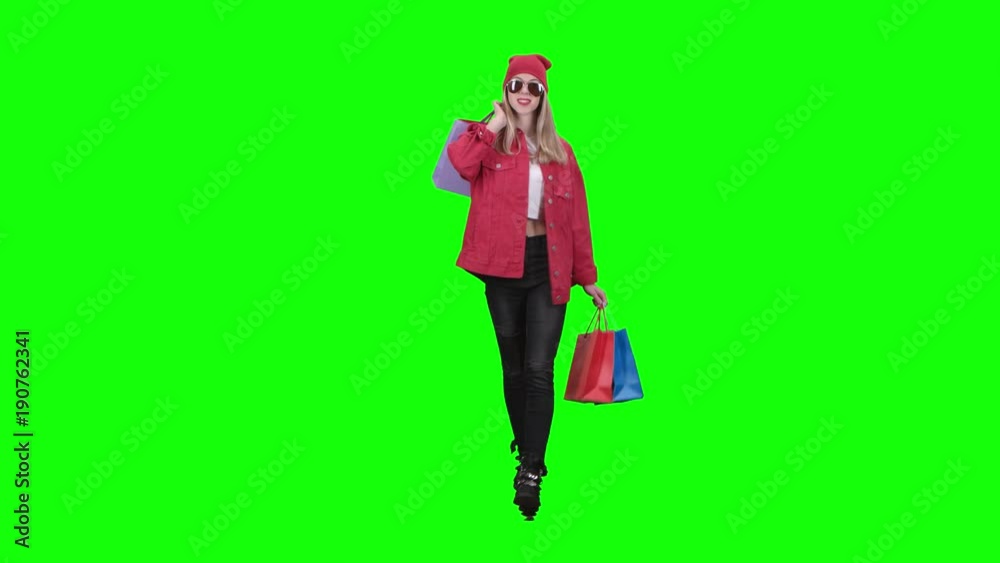 Girl is going shopping with a lot of packages . Green screen Girl is going shopping with a lot of packages . Green screen