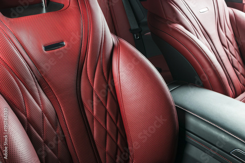 Modern Luxury car inside. Interior of prestige modern car. Comfortable leather red seats. Red perforated leather cockpit with isolated Black background. Modern car interior details © Aleksei