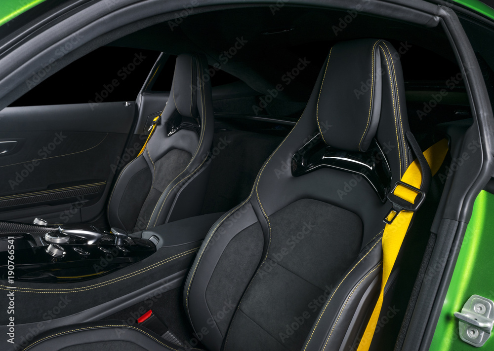 Modern Luxury sport car inside. Interior of prestige car. Leather seats with yellow stitching. Black perforated leather. Modern car interior details. Automatic gear stick shift. Media Buttons