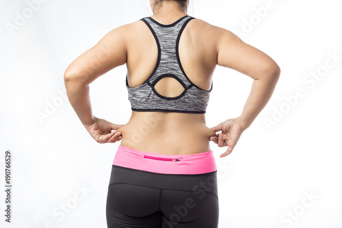 Overweight woman hand pinching excessive belly fat on gray background, Healthy concept © suriya
