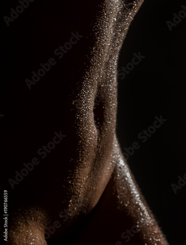 sexy nude female body with water drops on a black background