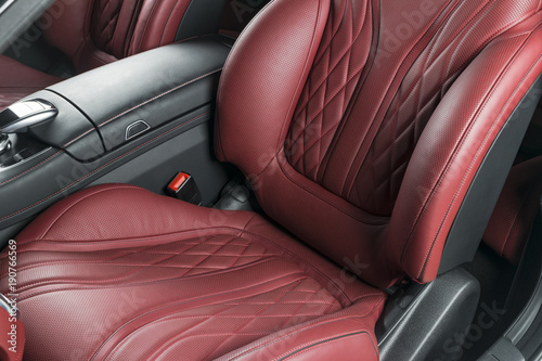 Modern Luxury car inside. Interior of prestige modern car. Comfortable leather red seats. Red perforated leather cockpit with isolated Black background. Modern car interior details © Aleksei