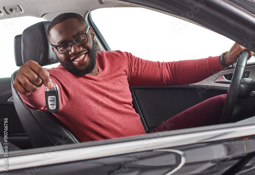 Photography Happy handsome african man showing car keys in his newly bought auto smiling che