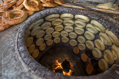 Φωτογραφία baking naan flat breads in the tradional stove,xinjiang,china