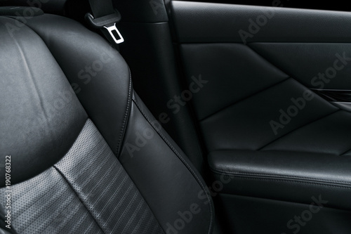 Modern luxury car black perforated leather interior. Part of leather car seat details. Modern car interior details © Aleksei