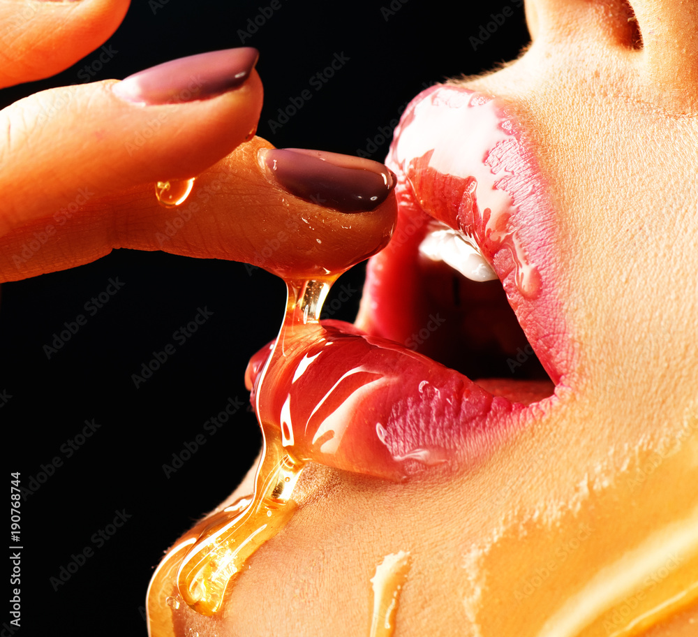 Honey dripping on sexy girl lips. Beauty model woman eating honey. Closeup  image Stock Photo | Adobe Stock