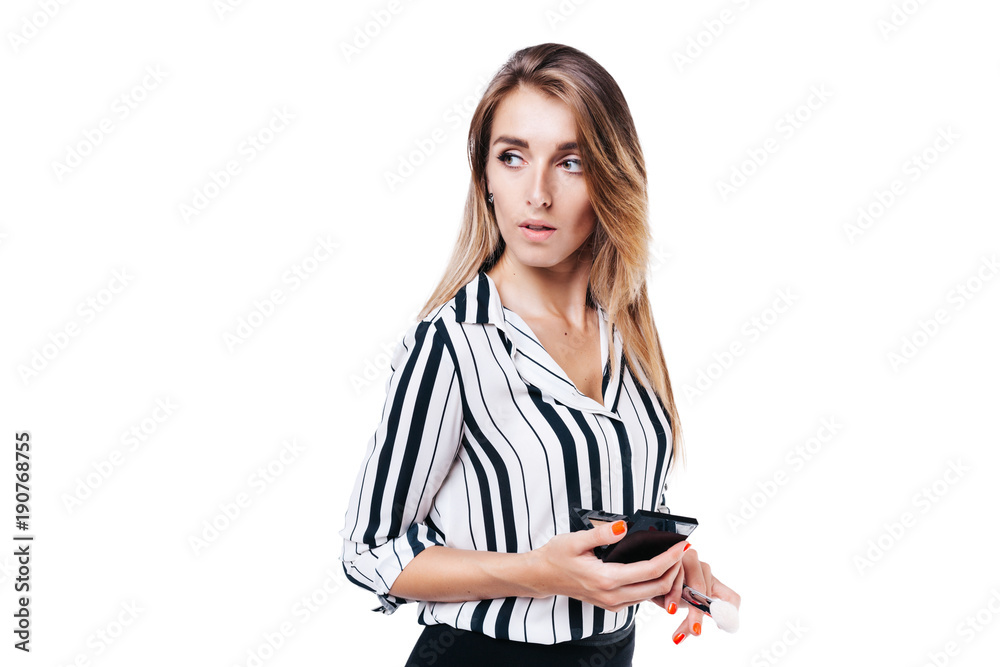 beautiful girl make-up artist with beautiful hair in a striped shirt on a white background in whose hands tassels and other makeup accessories beautiful girl make-up artist with beautiful hair in a striped shirt on a white background in whose hands tassels and other makeup accessories