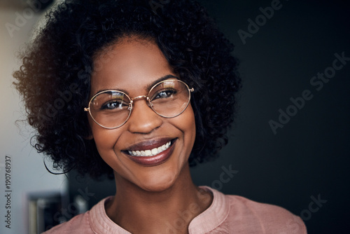 Smiling young African businesswoman standing in an office