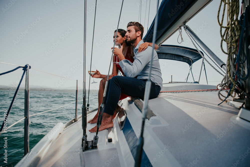 happy couple taking a romantic cruise on the sail boat happy couple taking a romantic cruise on the sail boat
