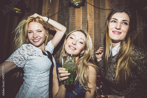 Party girls in a restaurant celebrating with drinks and champagne
