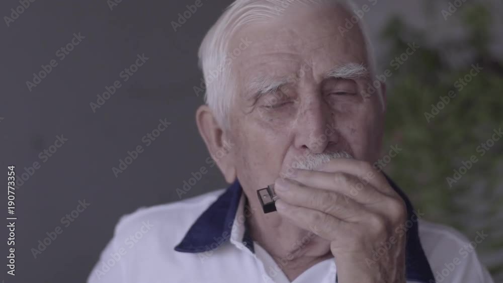 Elderly playing harmonica Elderly playing harmonica