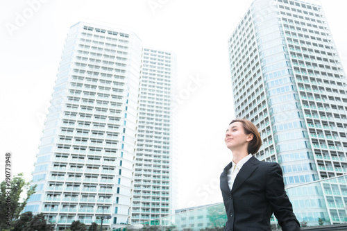 高層ビルを前にリラックスする女性 © chachamal
