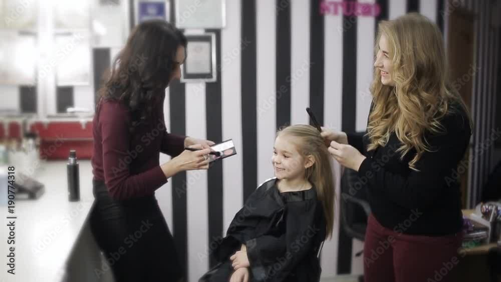 Master hair and make-up master also working on a small client in beauty salon Master hair and make-up master also working on a small client in beauty salon