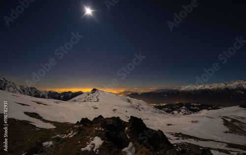 Turin city lights, night view from snow covered Alps by moonlight. Moon and Orion constellation, clear sky, fisheye lens. Italy. © fabio lamanna