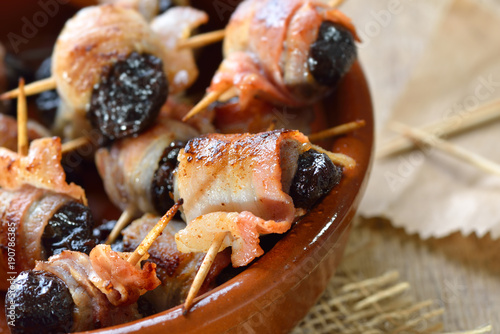 Leckere spanische Tapas: Getrocknete Pflaumen in Speck gerollt und gebraten – Delicious Spanish tapas:  Fried prunes wrapped in bacon photo