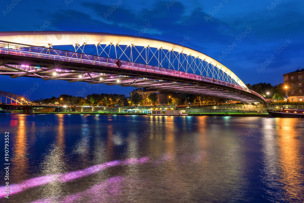 Fototapeta premium Bernatka footbridge over Vistula river in Krakow at night. Poland. Europe.