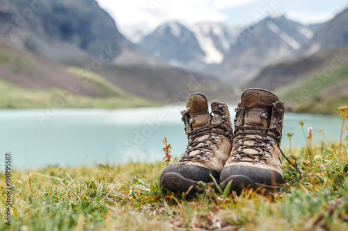 hiker boots standing on grass near lake in Altai mountains